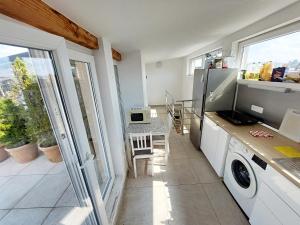 a kitchen with a washer and dryer and a table at Bella Lubiana in Ljubljana