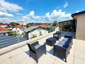 a patio with chairs and tables on a roof at Bella Lubiana in Ljubljana
