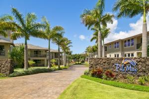 a driveway in front of a building with palm trees at Pili Mai 8K in Koloa