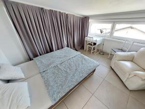 a room with a bed and a couch and a window at Bella Lubiana in Ljubljana