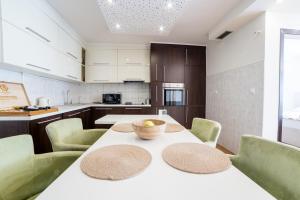 a kitchen with a table with a bowl of fruit on it at Skenderija Skyline Luxury- 2BR Apartment with Garage and Balcony in Sarajevo +13 photos