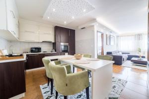 a kitchen and living room with a table and chairs at Skenderija Skyline Luxury- 2BR Apartment with Garage and Balcony in Sarajevo