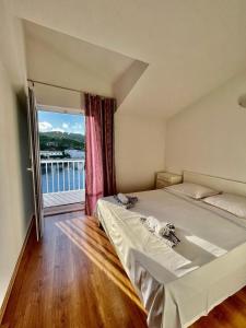 a bedroom with a large bed and a large window at Apartments by the sea Povlja, Brac - 21810 in Povlja