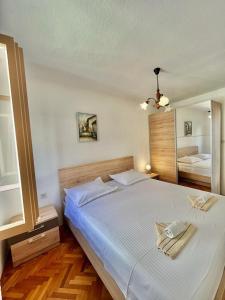 a bedroom with a large bed with two towels on it at Apartments by the sea Povlja, Brac - 21810 in Povlja +16 photos