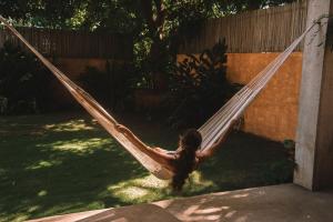 a girl sitting in a hammock in a yard at Casa Marisa in Puerto Escondido