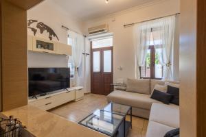a living room with a couch and a tv at The Neo-Classic Loft in Rhodes Town