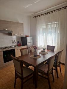 a dining room table with chairs and a kitchen at Seaside holiday house Gradac, Makarska - 24759 in Gradac
