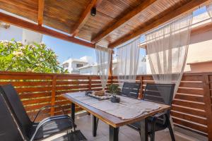 a wooden table and chairs on a balcony at The Neo-Classic Loft in Rhodes Town