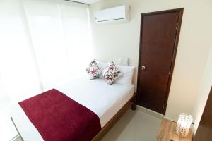 a small bedroom with a bed and a closet at hotel sierra nevada centro histórico in Santa Marta