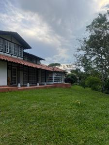 a building with a grass field in front of it at Casa campestre con encanto in Armenia +20 photos