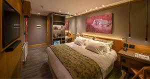 Una habitación de hotel con una cama y un televisor de pantalla plana. en Wood Hotel Gramado, en Gramado