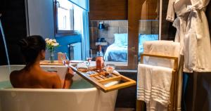 a woman sitting in a bath tub in a bathroom at Wood Hotel in Gramado +78 photos