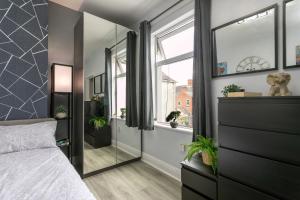 a bedroom with a bed and a large mirror at The Regent - Stylish Luxury Leicester Studio near City Centre! in Leicester +58 photos