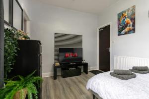 a living room with a tv and a bed at The Regent - Stylish Luxury Leicester Studio near City Centre! in Leicester
