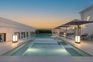 a swimming pool with lights in a building at Souphattra Hotel Vientiane in Vientiane