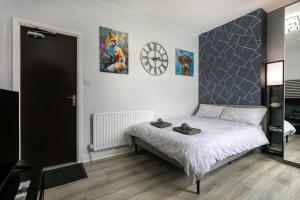 a bedroom with a bed and a clock on the wall at The Regent - Stylish Luxury Leicester Studio near City Centre! in Leicester