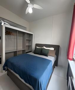 a bedroom with a blue bed and a ceiling fan at Apartment perto Praia e Metro, Melhor Localização in Rio de Janeiro