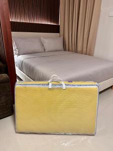 a yellow suitcase sitting on the floor next to a bed at Tey Spot in Iloilo City