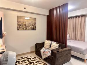 a bedroom with a bed and a chair and a bed at Tey Spot in Iloilo City