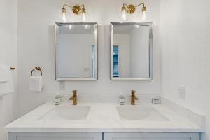 a white bathroom with two sinks and two mirrors at Hilltop Retreat in Fredericksburg