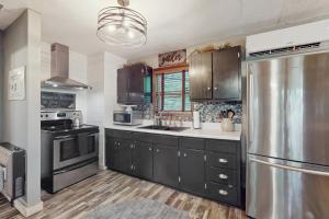 una cucina con mobili neri e un frigorifero in acciaio inossidabile di Tiptop Treehouse a Ellijay