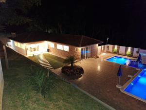 an aerial view of a house with a swimming pool at night at Recanto Sampaio in Castro