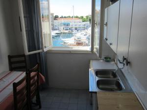 kuchnia ze zlewem i oknem z portem w obiekcie Apartment ML w mieście Zadar
