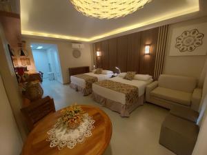 a hotel room with two beds and a table at Búzios Beach Resort Apartamento Luxo Home Premium 2 in Búzios