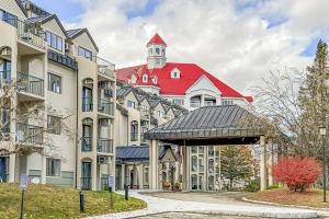 a building with a red roof with a clock tower at South Peak Condo at Rivergreen in Lincoln