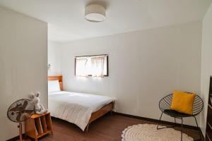 a bedroom with a bed and a fan and a chair at Jejuya Pyoseon in Seogwipo