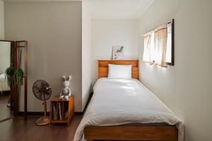 a bedroom with a bed and a fan at Jejuya Pyoseon in Seogwipo