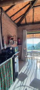 a kitchen with a table and a counter top at Chalé estrela do cruzeiro in São Thomé das Letras