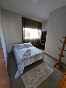 a bedroom with a large bed with a window at Flat Santa Teresa in Campo Verde
