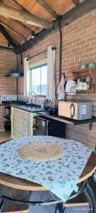 a kitchen with a table and a counter top at Chalé estrela do cruzeiro in São Thomé das Letras +22 photos
