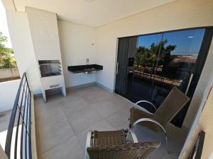 a balcony with chairs and a sink and a view of the ocean at Flat Santa Teresa in Campo Verde
