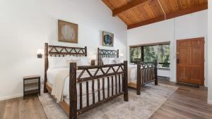 Un dormitorio con dos camas y una puerta de madera. en Camp Nelson Lodge Room 9, en Ponderosa