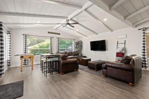 a living room with leather furniture and a flat screen tv at Whispering Pines | Yosemite in Oakhurst