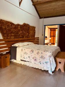 a bedroom with a bed and a brick wall at Fazenda Brotas SP in Brotas