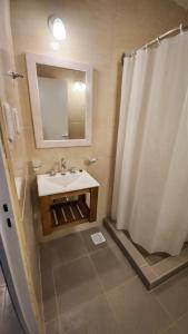 a bathroom with a sink and a shower with a mirror at Alojamientos Litoral - España 4 in Gualeguaychú