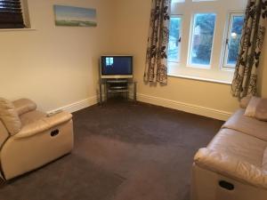 a living room with a couch and a television at Whitwell in Worksop