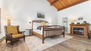 PonderosaCamp Nelson Lodge Room 6的一间卧室配有一张床、一把椅子和一个壁炉