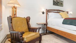 PonderosaCamp Nelson Lodge Room 6的一间卧室配有一张床、一把椅子和一盏灯