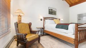 PonderosaCamp Nelson Lodge Room 6的一间卧室配有一张床、一把椅子和一盏灯