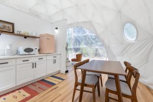 eine Küche mit Tisch und Stühlen in einem Zimmer in der Unterkunft Dome Sweet Dome | Shaver Lake in Shaver Lake
