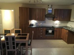 a kitchen with wooden cabinets and a table and a stove at Whitwell in Worksop