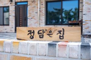 a sign sitting on top of a brick wall at Uljin Jeongdam-eun Ocean View Pension in Uljin