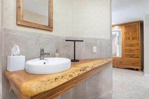 baño con lavabo blanco en una encimera de madera en Big Pine Suite CN Lodge R#1, en Ponderosa