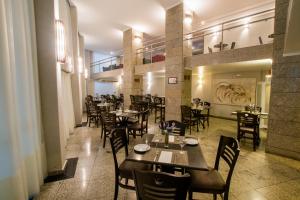 a restaurant with tables and chairs in a room at SJ Royal - San Juan Curitiba in Curitiba