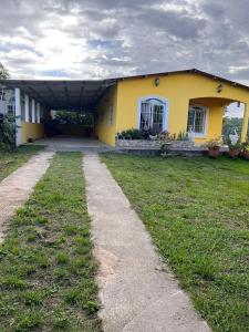 a yellow house with a path in front of it at Poptún, Peten home accommodation in Ixobel