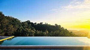 a swimming pool with trees in the background at Dudu Cottage Nusa Penida in Nusa Penida
